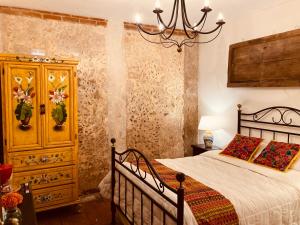 a bedroom with a bed and a chandelier at Luna Maya Antigua in Antigua Guatemala