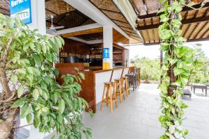 a bar with wooden chairs and a counter in a restaurant at Bernis Hostel in Moalboal