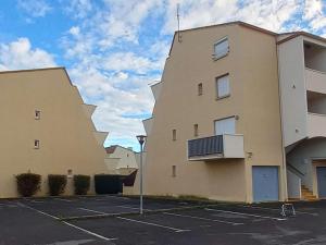 twee hoge gebouwen op een parkeerplaats met een hemel bij Appartement Marseillan-Plage, 2 pièces, 4 personnes - FR-1-387-70 in Marseillan