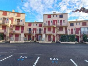 eine Reihe von Apartmenthäusern auf einem Parkplatz in der Unterkunft Appartement Marseillan-Plage, 2 pièces, 4 personnes - FR-1-387-162 in Marseillan
