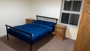1 dormitorio con 1 cama azul y 2 mesitas de noche en Two bedroom Entire Apartment in Roman road with Free Parking, en Middlesbrough
