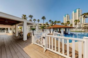 a resort deck with a pool and a building at Gulf Point Condominiums #1314 in South Padre Island