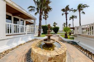 a fountain in front of a house with palm trees at Gulf Point Condominiums #1314 in South Padre Island