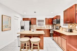 a kitchen with wooden cabinets and a island with stools at Blue on Fox Run in Apollo Beach
