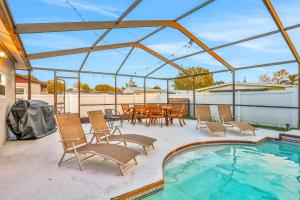 a patio with a table and chairs and a pool at Blue on Fox Run in Apollo Beach