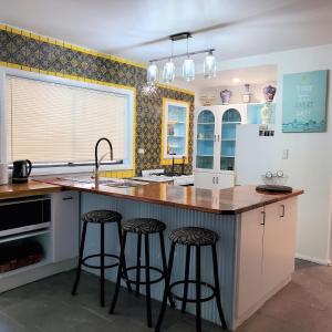 una cocina con encimera y taburetes en una isla de cocina en CHAP41C - Coco Veranda, en Callala Bay