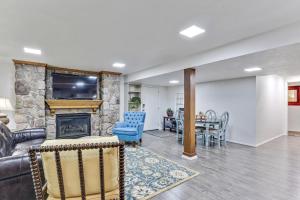 a living room with a stone fireplace and a table at Heart of Orem Basement 3 bedroom Apartment w/ Waffles. in Orem