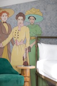 een slaapkamer met een muurschildering van twee vrouwen en een bed bij The House Hotel Old Tbilisi in Tbilisi City