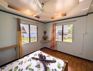 a bedroom with a bed with a teddy bear on it at 1peace beach resort in Anda