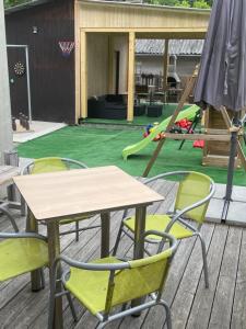 a table and chairs on a deck with a playground at Apartment WELLNESS Vlčková in Vlčková