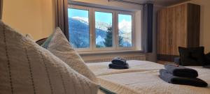 a bedroom with two towels on a bed with a window at Haus Tisch in Schruns-Tschagguns