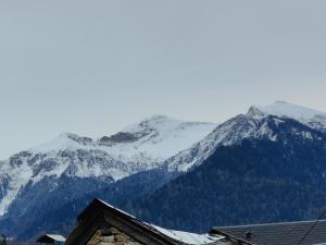 a mountain covered in snow with a house in the foreground at Appartement Boutx 4 PERSONNES in Boutx +4 photos