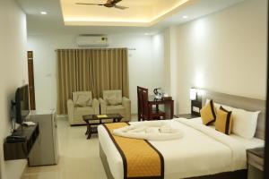 a bedroom with a large bed and a living room at RJ ROSS RAMAPURAM in Munnar