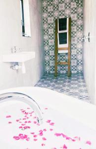 Pretoria的住宿－Rocky Road Mountain Lodge，浴室设有水槽和鲜花浴缸。