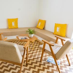 カラングートにあるBloomrooms Calanguteのソファ、椅子、テーブルが備わる客室です。