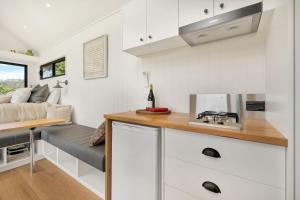 uma cozinha com um sofá numa pequena casa em Altitude Kangaroo Valley em Kangaroo Valley