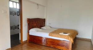 a bedroom with a wooden bed in a room at Pears Garden Royal Suite in Kodaikānāl