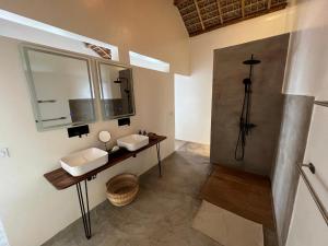a bathroom with two sinks and a mirror at Canopee Lodge in Nosy Komba +48 photos