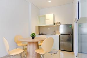 a kitchen with a table and chairs and a refrigerator at TwoSpaces Living at Zena Mozia in Tegal