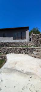 ein Haus mit einer Steinmauer und einem Gebäude in der Unterkunft Дом с красивым видом in Arzni