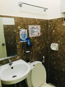 a bathroom with a sink and a toilet and a mirror at Queen's Room Rental 3 in El Nido +12 photos