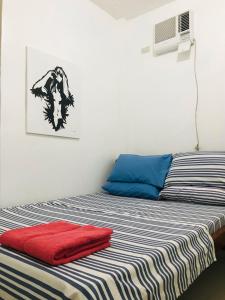 a bedroom with a bed with red and blue sheets at Queen's Room Rental 3 in El Nido