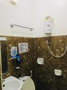 a bathroom with a toilet and a sink at Queen's Room Rental 3 in El Nido