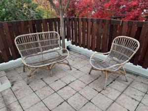 two chairs sitting on a patio in front of a fence at Super t6 avec terrasse à Cergy in Cergy