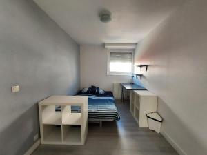 a small bedroom with a bed and a window at Super t6 avec terrasse à Cergy in Cergy