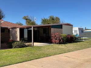 a house with a porch and a garage at Leander Reef Holiday Park in Port Denison