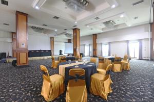 een vergaderzaal met tafels en stoelen en een podium bij Hotel Kaisar in Jakarta