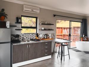 a kitchen with a counter and a sink and a tub at Rocky Road Mountain Lodge in Pretoria