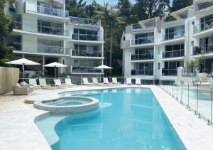 un'immagine di una piscina di fronte a un edificio di The Cove Noosa - Apartment 14 a Noosa Heads