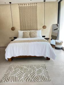 een slaapkamer met een groot bed en een tapijt bij Xuncari Ecoluxury Living in Tulum