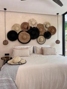 een bed met hoeden aan de muur bij Xuncari Ecoluxury Living in Tulum