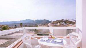 a white table and chairs on a balcony with mountains at Casas María Carmona - Casa Luna Níjar by Ruralidays in Níjar