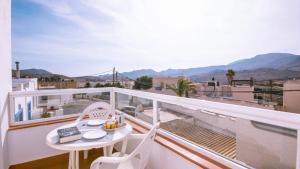 a balcony with a table and chairs and mountains at Casas María Carmona - Casa Luna Níjar by Ruralidays in Níjar
