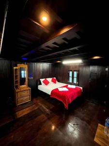 a bedroom with a large bed with a red blanket at Nature Castle in Kottakamboor