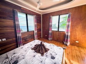 a bedroom with a large bed in a room with windows at 1peace beach resort in Anda