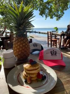 een bord pannenkoeken en fruit op een tafel met een ananas bij Xoot’ka’ana Villa Colibri in Bacalar