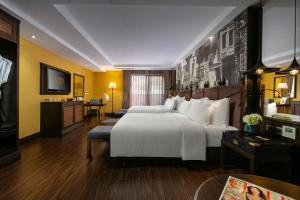 Hanoi Lion Boutique Hotel في هانوي: غرفه فندقيه سريرين وتلفزيون