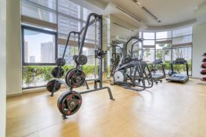 un gimnasio con equipo cardiovascular en una gran sala con ventanas en RP Heights, Downtown Dubai - Mint Stay en Dubái