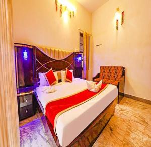 1 dormitorio con 1 cama grande con manta roja en FabEscape Queens Paradise en Pondicherry