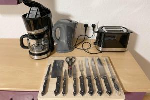 a cutting board with knives and a blender on a counter at City apartment with Wifi near Jena in Kahla