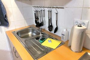 encimera con fregadero y utensilios de cocina en City apartment with Wifi near Jena, en Kahla