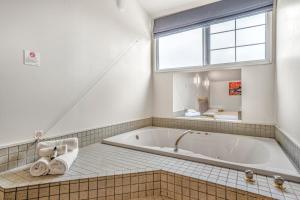 a bath tub in a bathroom with a window at Capital Lodge Motor Inn in Wellington