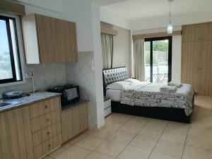 sypialnia z łóżkiem oraz kuchnia z oknem w obiekcie Valentina Apartments w Pafos