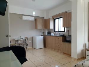 a kitchen with a white refrigerator and a table at Valentina Apartments in Paphos