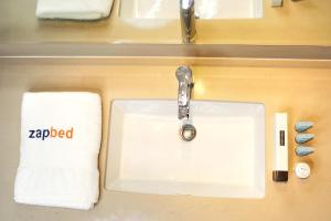 umywalka w łazience z ręcznikiem i ręcznikiem w obiekcie ZAPBED House - Luxury Holiday Homes in Yas Island w Abu Zabi