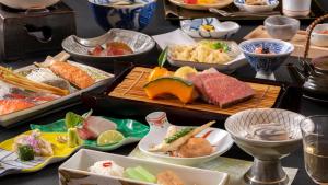a table filled with different types of food on plates at Shionoyu Onsen Rengetsu in Nasushiobara